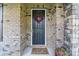 Close-up of the front door, complete with a decorative wreath, flowers and welcome mat at 1004 Princesa Dr, Matthews, NC 28104