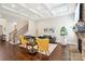 Spacious living room with hardwood floors, a fireplace, and a staircase leading to the upper level at 1004 Princesa Dr, Matthews, NC 28104