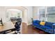 Well-lit home office with a blue sofa, modern desk, and hardwood floors at 1004 Princesa Dr, Matthews, NC 28104