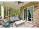 Relaxing covered patio with comfortable seating, a ceiling fan, and views of the wooded backyard at 1004 Princesa Dr, Matthews, NC 28104