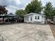 Quaint white house with boat parking, featuring a covered jet ski and spacious concrete driveway at 101 Dogwood Cir, New London, NC 28127