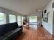 Bright living room featuring hardwood floors, a comfortable sofa, and serene outdoor view at 101 Dogwood Cir, New London, NC 28127