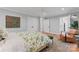 Bright bedroom with a floral bedspread, accent chair, hardwood floors, and ample natural light at 1118 Crestbrook Dr, Charlotte, NC 28211