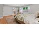 Light-filled bedroom with a floral bedspread, accent chair, hardwood floors, and ensuite bathroom access at 1118 Crestbrook Dr, Charlotte, NC 28211