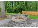 A cozy stone fire pit area with seating, ideal for outdoor gatherings and enjoying cool evenings at 1118 Crestbrook Dr, Charlotte, NC 28211