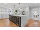 A modern kitchen featuring white cabinets, stainless steel appliances, a large island with marble countertop, and hardwood floors at 1118 Crestbrook Dr, Charlotte, NC 28211