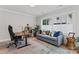 Home office featuring a gray sofa, a large window, a modern desk, and colorful decor at 1118 Crestbrook Dr, Charlotte, NC 28211