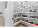 Well-organized pantry with white shelves, food supplies, and hardwood floors at 1118 Crestbrook Dr, Charlotte, NC 28211
