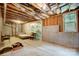 Unfinished basement with visible ceiling beams, concrete walls, and a window for natural light at 1150 Hearth Sw Ln, Concord, NC 28025