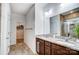 Bathroom featuring dual sinks with granite countertops, providing functionality and elegance, plus a walk-in closet at 1150 Hearth Sw Ln, Concord, NC 28025