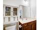 Cozy bathroom with dark wooden vanity, white sink, a large mirror, and a cabinet above the toilet at 1150 Hearth Sw Ln, Concord, NC 28025