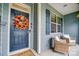 Inviting front porch with a wreath on the front door, wicker furniture, and blue shutters at 1150 Hearth Sw Ln, Concord, NC 28025