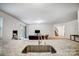 Modern kitchen featuring a granite countertop island with a sink and faucet, connected to an open-concept living area at 1150 Hearth Sw Ln, Concord, NC 28025