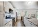 Well-lit kitchen featuring stainless steel appliances, white cabinets, granite countertops, and a modern faucet by the sink at 1150 Hearth Sw Ln, Concord, NC 28025