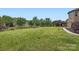 Manicured backyard with green grass, mature trees, and an outdoor pergola at 117 Fellspoint Rd, Mooresville, NC 28115