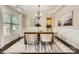 Elegant dining room with tray ceilings, wainscoting, a stylish chandelier, and abundant natural light at 117 Fellspoint Rd, Mooresville, NC 28115