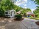 Spacious backyard featuring a pool house, stamped concrete patio, and well-manicured lawn, ideal for outdoor living at 1209 S South St, Gastonia, NC 28052