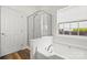 Bright bathroom featuring a soaking tub, a separate glass door shower, and wood look floor tiles at 124 Shephard Hill Dr, Mooresville, NC 28115
