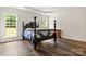 Spacious bedroom with a four-poster bed, hardwood floors, and abundant natural light from large windows at 124 Shephard Hill Dr, Mooresville, NC 28115