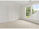 Bright bedroom with neutral carpet, two windows, and white doors at 124 Shephard Hill Dr, Mooresville, NC 28115