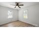 A simple bedroom with a ceiling fan, two windows and wooden floors at 135 Mcshag Dr, Kannapolis, NC 28081
