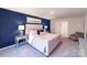 Stylish bedroom featuring a plush upholstered bed frame, elegant blue accent wall, and carpet flooring at 136 Meadow View Dr, Statesville, NC 28677