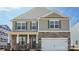Charming two-story home featuring stone accents, gray siding, and a two-car garage at 140 Meadow View Dr, Statesville, NC 28677