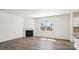 Living area with wood floors features a cozy fireplace, a large window and natural light at 140 Meadow View Dr, Statesville, NC 28677