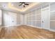 Large bedroom with custom paneling, hardwood floors, tray ceiling, and ample natural light at 14119 Shelburne Village Dr, Charlotte, NC 28278