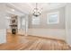 Bright dining room with hardwood floors, fireplace, wainscoting, and modern chandelier at 14119 Shelburne Village Dr, Charlotte, NC 28278
