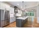 Gourmet kitchen boasts stainless steel appliances, a large island with sink, and custom cabinetry at 14119 Shelburne Village Dr, Charlotte, NC 28278