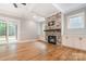 Spacious living room featuring a brick fireplace, white built-in cabinets, hardwood floors, and sliding glass doors at 14119 Shelburne Village Dr, Charlotte, NC 28278