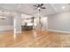 Open living room with hardwood floors, coffered ceiling, leading into an open kitchen and stairwell at 14119 Shelburne Village Dr, Charlotte, NC 28278