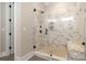 Luxurious shower with glass enclosure, marble tile, and built-in bench at 14119 Shelburne Village Dr, Charlotte, NC 28278