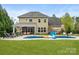 Beautiful backyard with pool, patio, outdoor seating, and lush green lawn at 1515 Millbridge Pkwy, Waxhaw, NC 28173