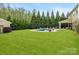 Large, well-maintained backyard with a pool, covered patio, and mature landscaping, ideal for outdoor living and entertaining at 1515 Millbridge Pkwy, Waxhaw, NC 28173