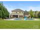 Expansive backyard featuring a large in-ground pool, lounge chairs, covered patio and green lawn perfect for outdoor enjoyment at 1515 Millbridge Pkwy, Waxhaw, NC 28173