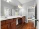 Bathroom features hardwood floors, double sinks, and dark wood cabinets at 1515 Millbridge Pkwy, Waxhaw, NC 28173