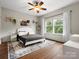 Bedroom with white walls, hardwood floors, and large window with view of the outside at 1515 Millbridge Pkwy, Waxhaw, NC 28173