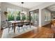 Sunlit dining room features hardwood floors and large windows overlooking the backyard with french doors at 1515 Millbridge Pkwy, Waxhaw, NC 28173