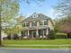 Charming two-story home featuring a covered front porch with stone accents, and a well-maintained lawn at 1515 Millbridge Pkwy, Waxhaw, NC 28173