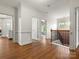 Hallway showing hardwood floors, white walls, and staircase with a wrought iron railing at 1515 Millbridge Pkwy, Waxhaw, NC 28173