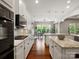 Bright, open kitchen featuring white cabinets, granite countertops, hardwood floors and modern stainless steel appliances at 1515 Millbridge Pkwy, Waxhaw, NC 28173