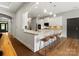Open concept kitchen and living area with granite counters, barstool seating and stainless steel appliances at 1515 Millbridge Pkwy, Waxhaw, NC 28173