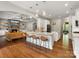 Open-concept kitchen flows to living room, featuring granite counters, stylish seating and stone fireplace at 1515 Millbridge Pkwy, Waxhaw, NC 28173