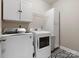 Clean laundry room with modern washer and dryer, storage cabinets, and patterned tile floor at 1515 Millbridge Pkwy, Waxhaw, NC 28173