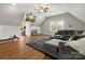 Spacious living room with large sectional sofa, TV, exercise equipment, and hardwood floors at 1515 Millbridge Pkwy, Waxhaw, NC 28173