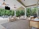 Covered patio with comfortable seating, ceiling fans, outdoor television, and views of the backyard at 1515 Millbridge Pkwy, Waxhaw, NC 28173