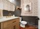 Stylish powder room with floral wallpaper, a gold-framed mirror, and a wooden vanity at 1515 Millbridge Pkwy, Waxhaw, NC 28173