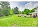 Manicured backyard showcasing a lush lawn, mature trees and landscaping, with a pool area providing a serene outdoor space at 15306 Gower Ct, Charlotte, NC 28278